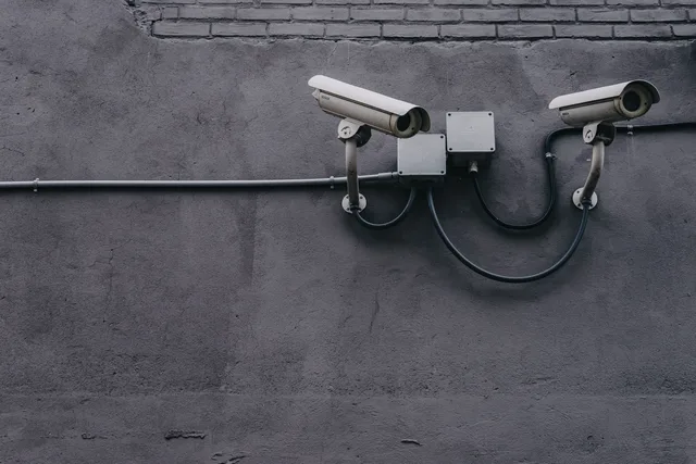 Two surveillance cameras mounted on a concrete wall, highlighting security technology. Einwilligung und Analytics in der Schweiz: Was die nDSG vorsieht